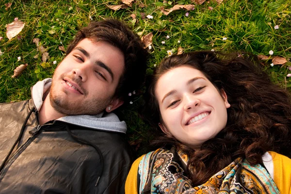 A couple of teenagers lying in the grass — Stock Photo, Image