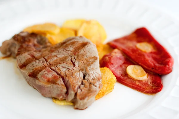 Bife de lombo com batatas fritas e pimentas vermelhas — Fotografia de Stock