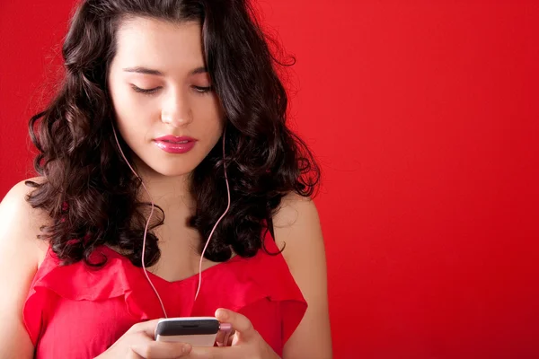 10 代の彼女の携帯電話で音楽を聴く — ストック写真