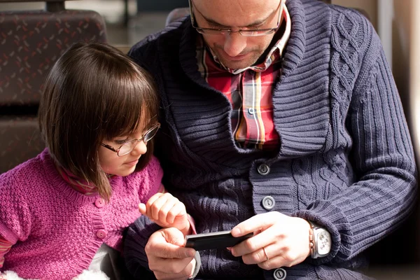 Father and daughter on train with smart phone — Stock Photo, Image
