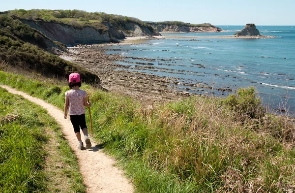 Niño caminando por un sendero sobre el mar . — Foto de Stock