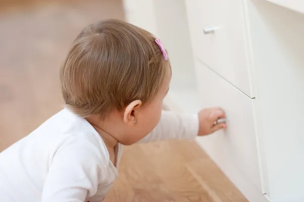 Bebê abrindo uma gaveta — Fotografia de Stock