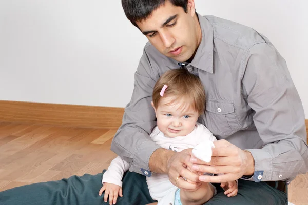 Papà non è molto abile vestire babys — Foto Stock