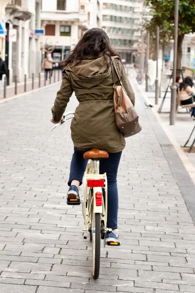 Kvinna cykling nerför gatan — Stockfoto