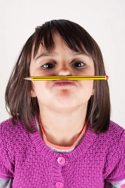 Niña sosteniendo un lápiz como un bigote . — Foto de Stock