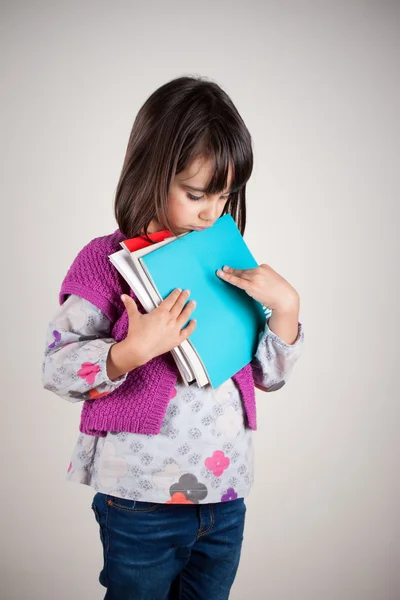 Trauriges kleines Mädchen mit Büchern — Stockfoto