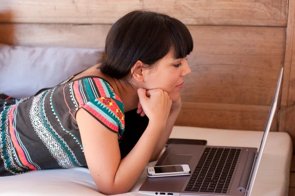 Genç kadın bir laptop bir şey izliyor — Stok fotoğraf