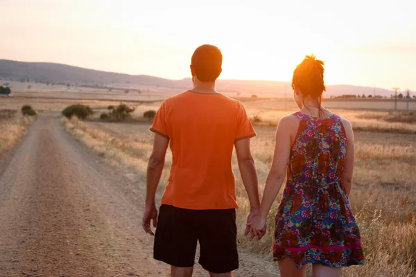 Pareja joven caminando al atardecer — Foto de Stock