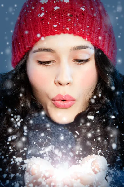 Menina de Natal soprando neve nas mãos — Fotografia de Stock
