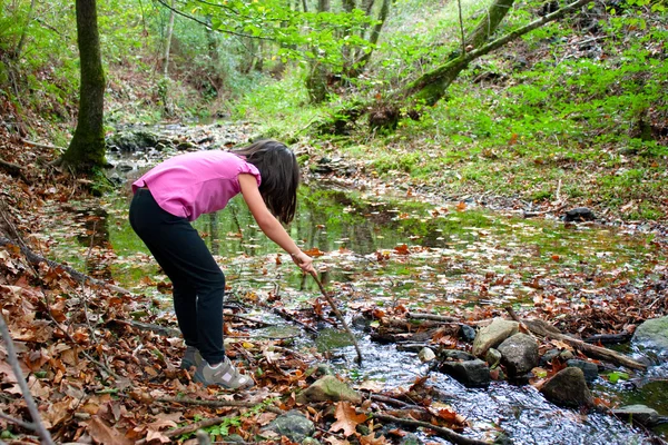 Маленькая девочка играет с водой в реке — стоковое фото