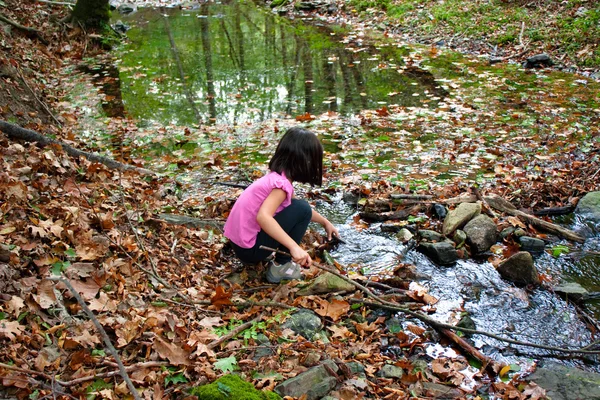 Petite fille jouant avec l'eau dans une rivière — Photo