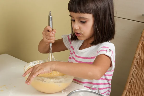 Süßes und glückliches kleines Mädchen beim Kuchenbacken — Stockfoto