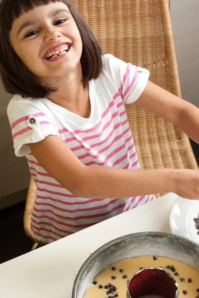 Glückliches kleines Mädchen beim Kochen eines Schokoladenchips Kuchen — Stockfoto