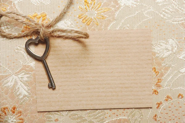 Heart shaped key on a paper card — Stock Photo, Image