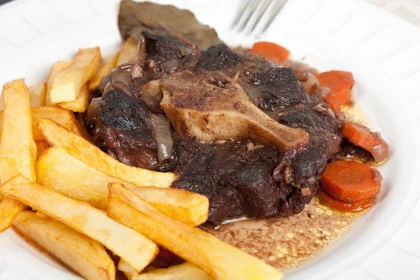 Oxtail stew with carrots and fries — Stock Photo, Image