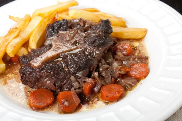 Oxtail stew with carrots and fries — Stock Photo, Image
