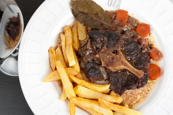 Oxtail stew with carrots and fries — Stock Photo, Image