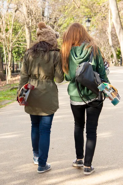 Two young girls walking skates in hand — Stock Photo, Image