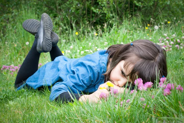 Çimlere yatan üzgün küçük kız — Stok fotoğraf