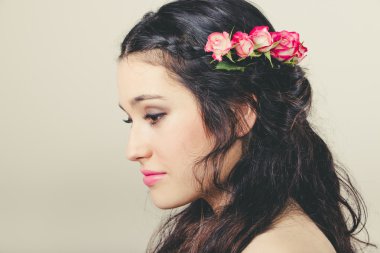 Beautiful brunette with roses in hair