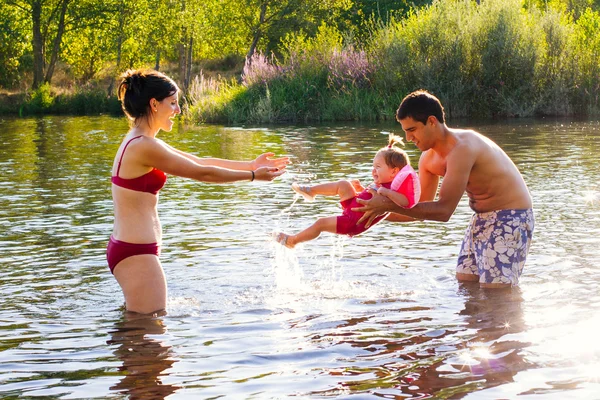 Junge Familie spielt im Wasser — Stockfoto