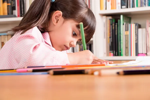 Klein meisje doet huiswerk — Stockfoto