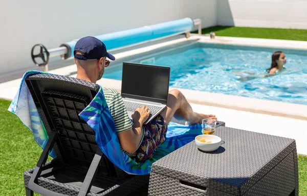 Расслабленный Взрослый Мужчина Работающий Над Ноутбуком Имеющий Аперитив Возле Бассейна — стоковое фото