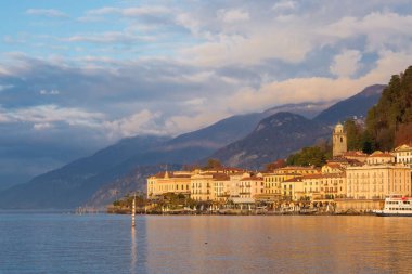 Bellagio, İtalya, Kasım 2021. Como Gölü kıyısındaki Bellagio İtalya 'nın küçük bir tatil köyü. Gölün güzel manzarası, gün batımında iskele..