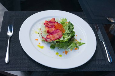 Kırmızı havyar ve salatada marine edilmiş somon. Somon, salatalık ve Lactuca yapraklı lezzetli sağlıklı salata. Düzgün beslenme. Romantik yemek..