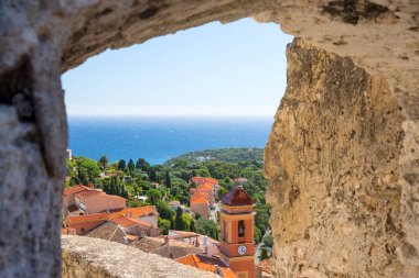 Monako yakınlarındaki Akdeniz kıyısındaki Roquebrune-Cap-Martin 'deki antik kalenin kalesinin penceresinden kilisenin manzarası. Cote d 'Azur boyunca yolculuk.