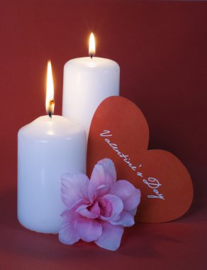 kırmızı bir arka plan üzerinde iki yanan mumlar