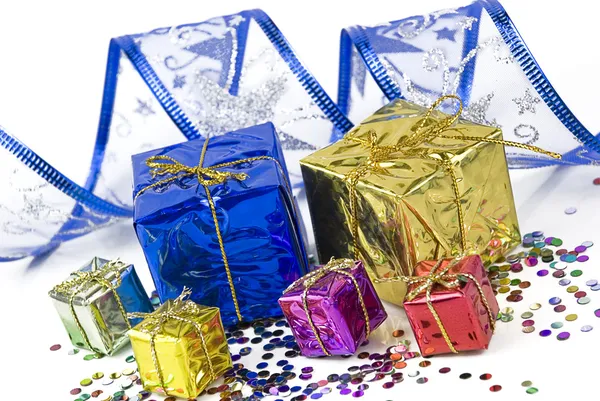 Pudełka i dekoracyjne wstążki na tle konfetti — Zdjęcie stockowe