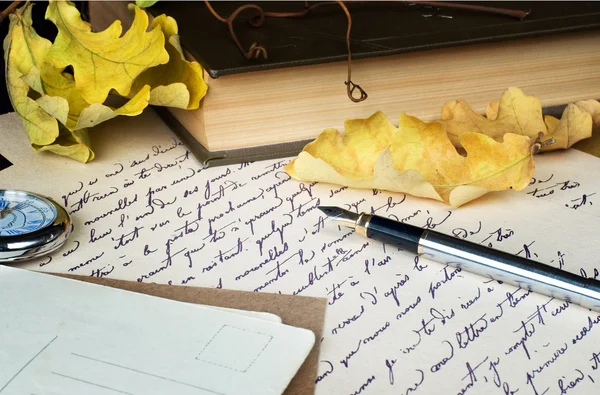 Старое письмо, перо, книга и желтые листья — стоковое фото