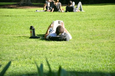 kitap okuma parkta yatan genç adam