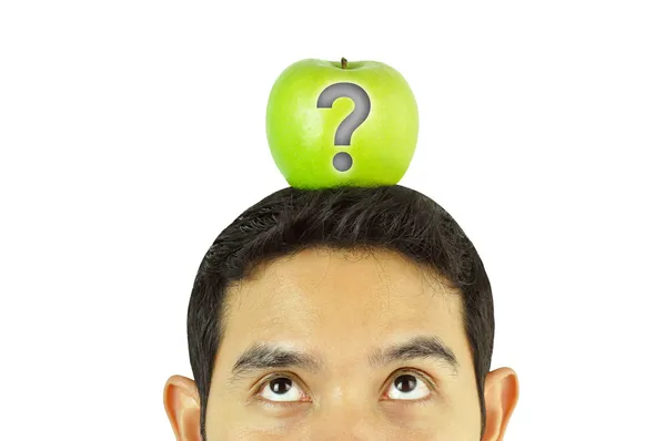 Человек смотрит на зеленое яблоко — стоковое фото