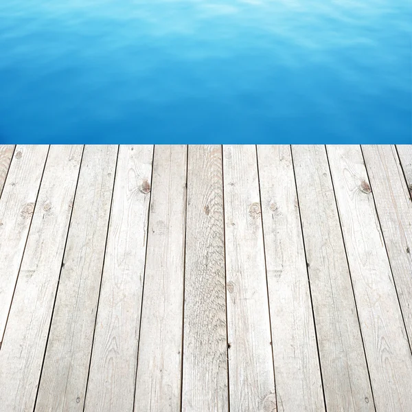 Houten plank op blauw water achtergrond — Stockfoto