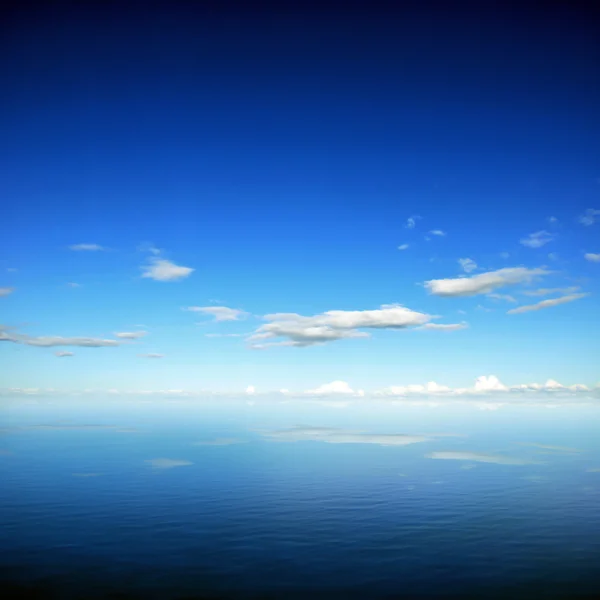 Ciel bleu et nuages avec réflexion sur l'eau de mer — Photo