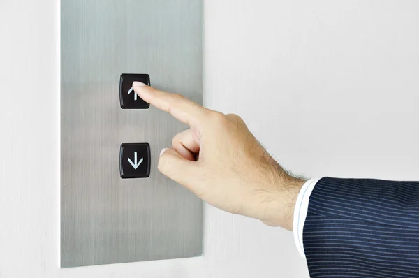 Businessman hand touching going up sign on lift control panel — Stock Photo, Image