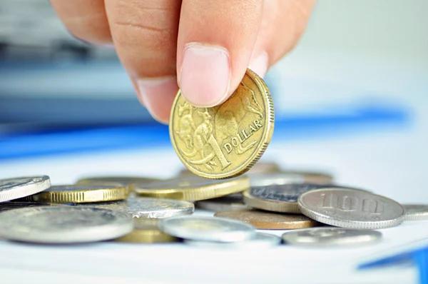 Fingrar plocka upp ett mynt - en australisk dollar (aud) — Stockfoto