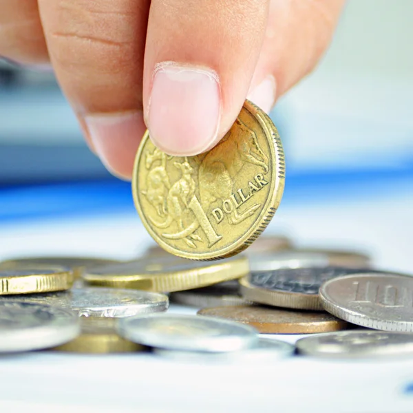 Los dedos recogiendo una moneda - un dólar australiano (AUD ) —  Fotos de Stock