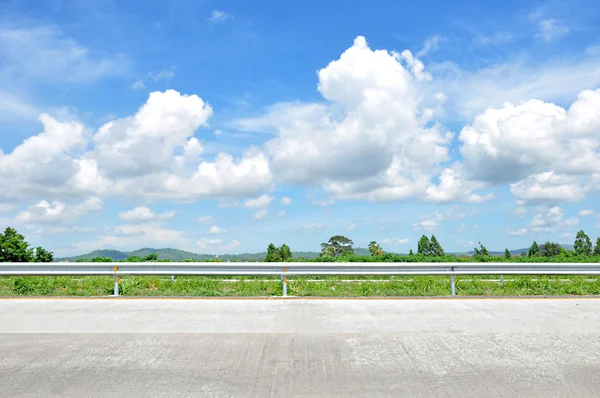 Yeşil doğa ve bulutlu mavi gökyüzü ile yol kenarında güzel manzara — Stok fotoğraf