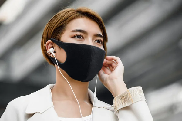 Jonge Aziatische Vrouw Draagt Gezichtsmasker Buiten Tijdens Het Luisteren Naar — Stockfoto