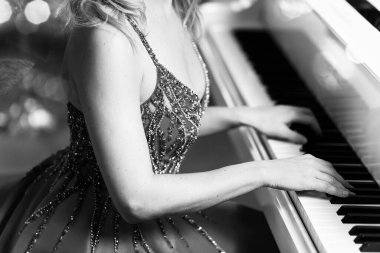 Piyanist beyaz piyano çalar. Ellerini tuşlara koy.