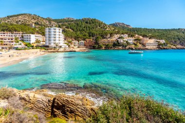 Mallorca Adası, Sant Elm 'deki plaj. Deniz kıyısı, gök mavisi deniz ve binalar
