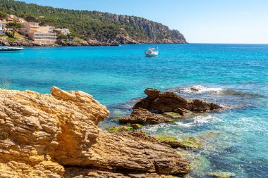 Mallorca Adası, Sant Elm 'deki plaj. Deniz kıyısı, gök mavisi deniz ve binalar