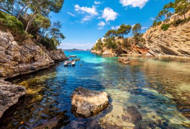 Mallorca Adası. Kayaların arasında küçük bir körfezde beyaz bir tekne.