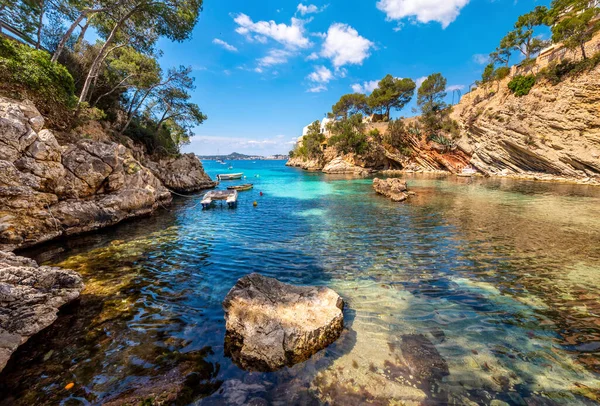 Mallorca Adası. Kayaların arasında küçük bir körfezde beyaz bir tekne.