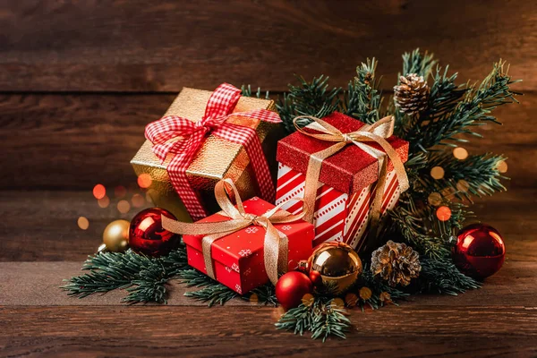 Merry Christmas! Box with a gift, Christmas balls and fir branches on a wooden background