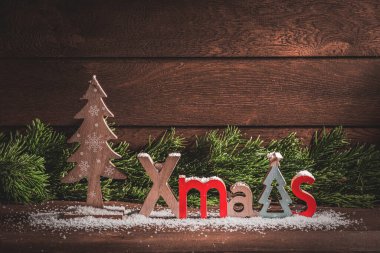 Mutlu noeller. Ahşap Noel süslemeleri ve ahşap bir arka planda köknar dalları