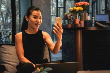 Business woman using a mobile phone for a distance face call and a laptop online. High quality photo